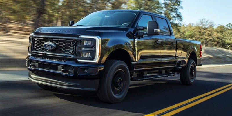 Black Ford Super Duty driving down highway